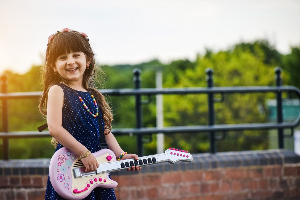 Kind mit Gitarre - Singen und Musizieren als Entspannungsübungen bei Stress
